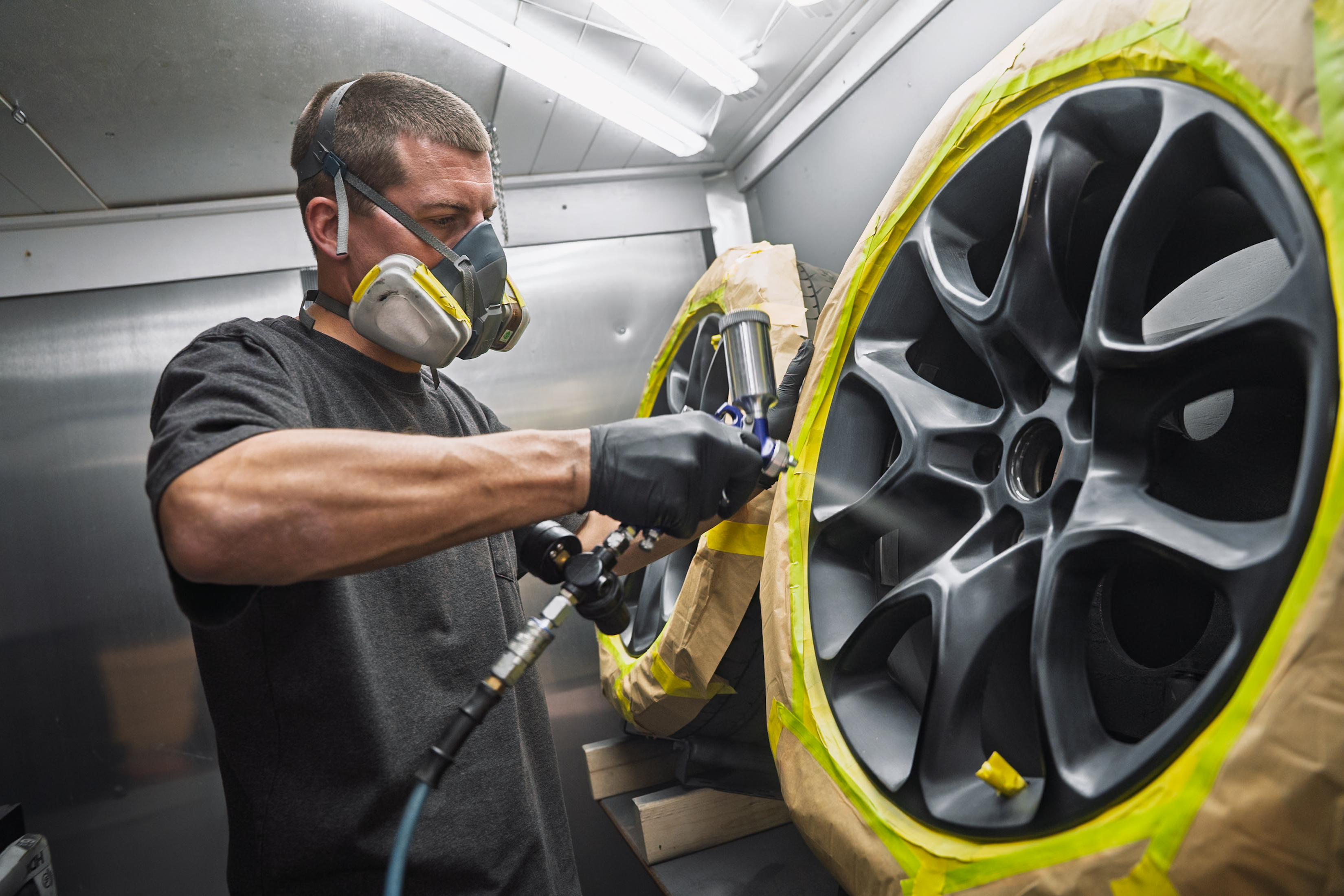 Wheel Squad technician spray-finishing an alloy wheel